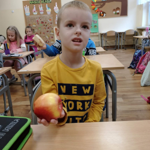 Uczeń klasy 1 prezentuje jabłko