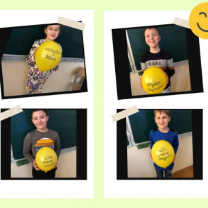Uczniowie z klasy 3a z balonikami na których są pozytywne słowa