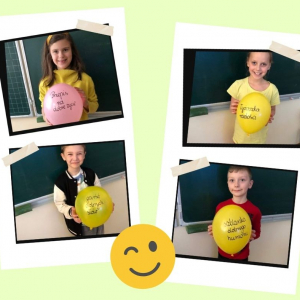 Uczniowie z klasy 3a z balonikami na których są pozytywne słowa 