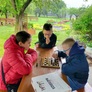 Uczniowie z klasy 5b grają w szachy pod wiatą