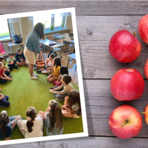 Święto Jabłka w klasie 1 - wychowawczyni częstuje uczniów jabłkami z koszyka