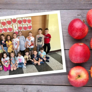 Święto Jabłka w klasie 1 - uczniowie na tle wystawy prac plastycznych.