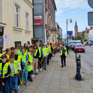 Marsz w ramach konkursu Odblaskowa Szkoła - uczniowie idą ulicą Krakowską