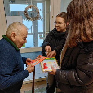 Wolontariuszki z naszego LO wręczają kartki z okazji Dnia Babci i Dziadka w ŚDS "Zielona Przystań" w Tarnowie