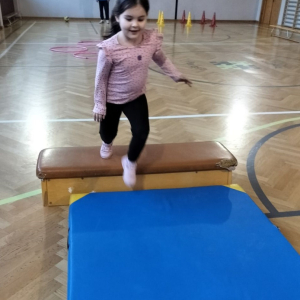 Dziewczynka podczas zajęć na sali gimnastycznej