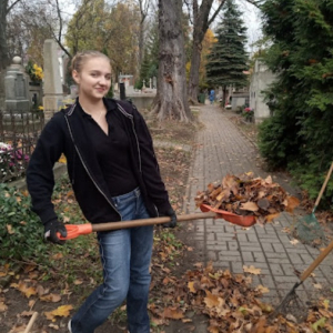 Uczennica XXLO zgarnia liście na Starym Cmentarzu