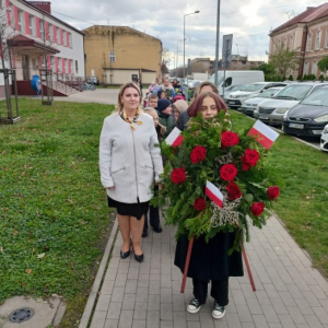 Przejście pod Dąb Pamięci Stefana Syrka z wieńcem i biało-czerwonymi flagami