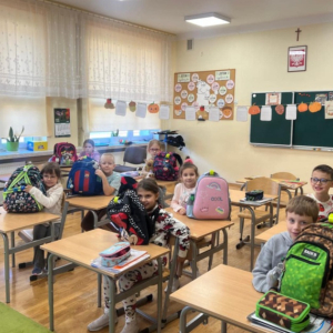 Uczniowie prezentują swoje plecaki z elementami odblaskowymi