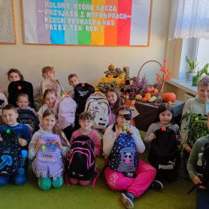 Uczniowie prezentują swoje plecaki z elementami odblaskowymi