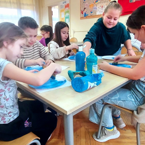 Dzieci malują elementy bałwanków