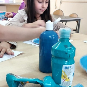 Dzieci malują elementy bałwanków