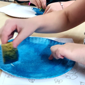 Dzieci malują elementy bałwanków