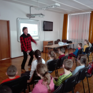 Na zdjęciu autor książki "Przygody Julka – Jestem Nowy" - Krzysztof Petek prowadzi prelekcję na auli szkolnej