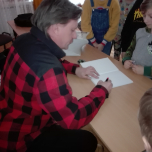 Na zdjęciu autor książki "Przygody Julka – Jestem Nowy" - Krzysztof Petek rozdaje autografy