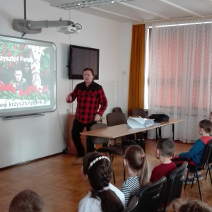 Na zdjęciu autor książki "Przygody Julka – Jestem Nowy" - Krzysztof Petek prowadzi prelekcję na auli szkolnej