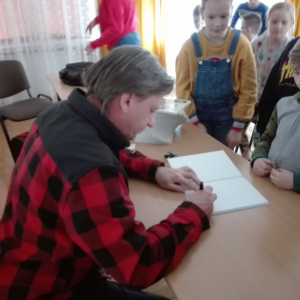 Na zdjęciu autor książki "Przygody Julka – Jestem Nowy" - Krzysztof Petek rozdaje autografy